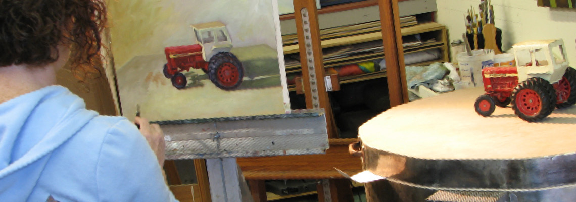 Woman paints toy tractor in painting class at Shane McDonald Studios