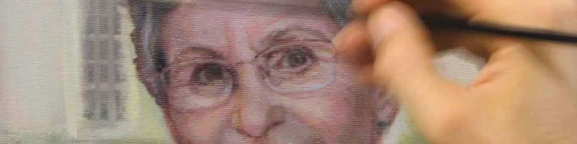artist's hand paints details on the face of a portrait subject, Bobbie Bailey