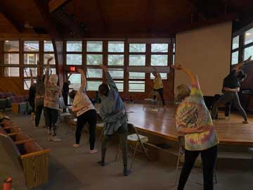 women stretch their right sides in a mountain pavilion