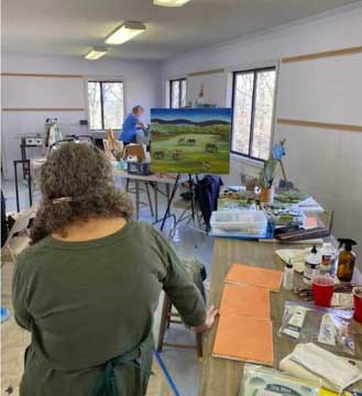 people working on paintings in a classroom