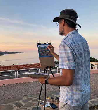 artist Shane McDonald wearing hat paints landscape