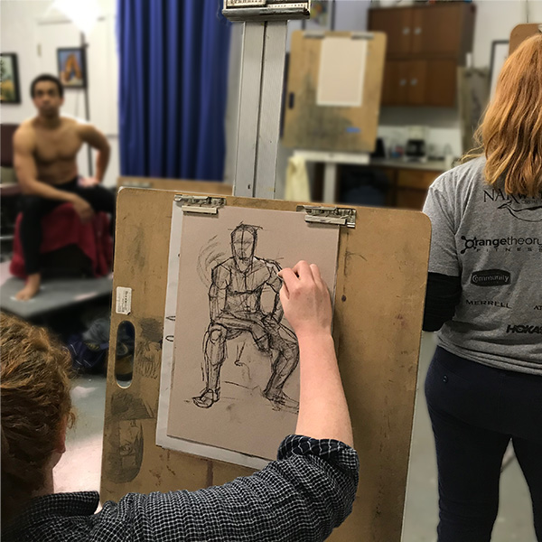 photo of an open life figure drawing and painting session with live human model