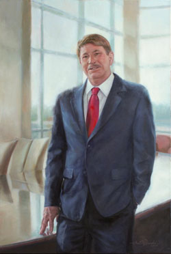 portrait of a businessman wearing a red tie and jacket in a conference room with large light-filled windows
