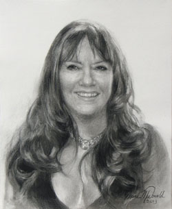 charcoal head and shoulders portrait of smiling woman with long wavy hair and low neck line