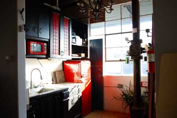 artist's studio kitchenette with stainless steel sink, microwave and refrigerator